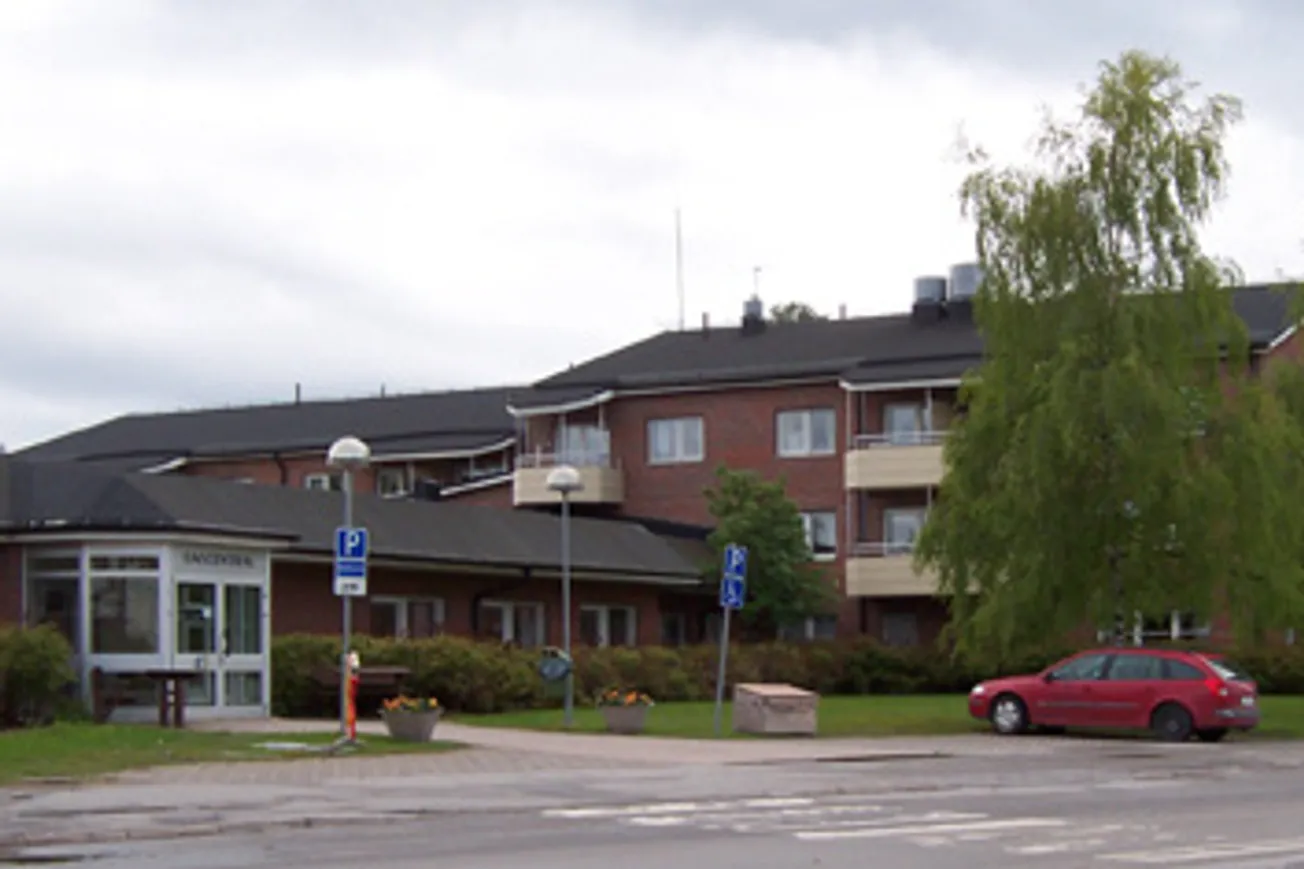 En röd bil som står parkerad vid sidan av en väg.