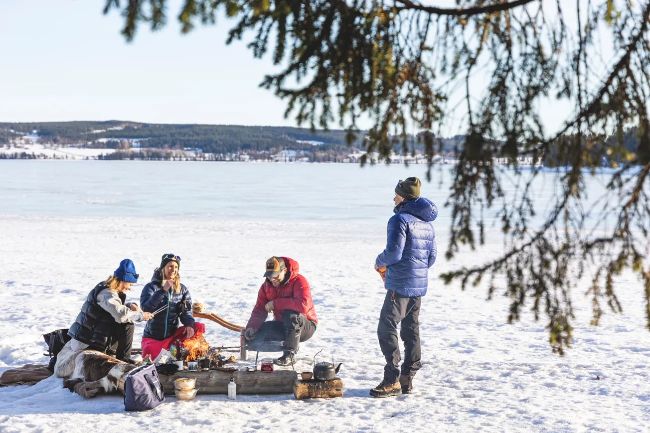 En grupp människor som sitter på en snötäckt mark.