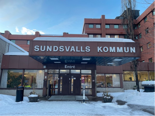 Kommunhusentrén med mycket snö på taket över dörrarna. 