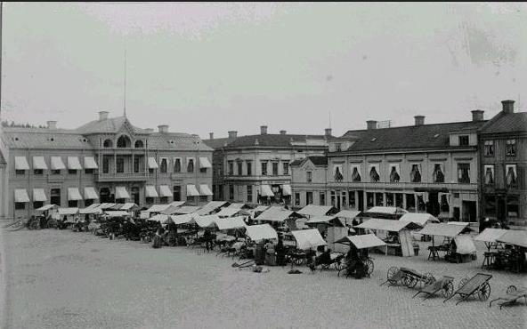 Gammal bild över Stora torget med marknadsstånd uppradade.