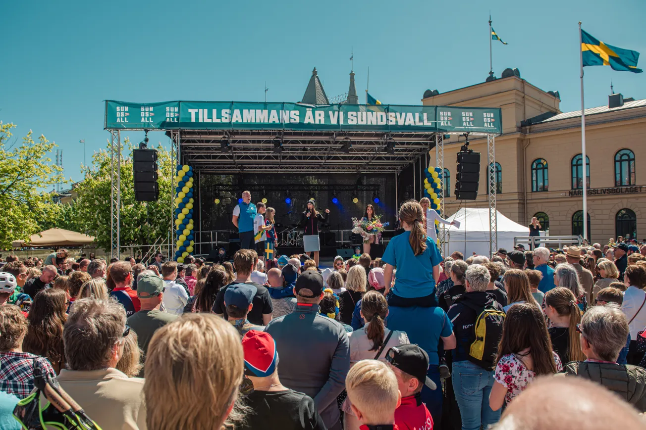 En folkmassa som står runt en scen.