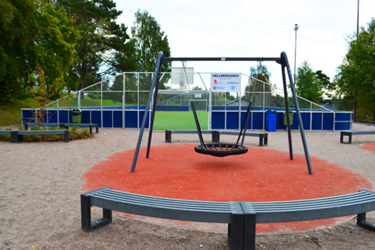 Multiarena med konstgräs och sarg runt om. Framför arenan finns en gunga.