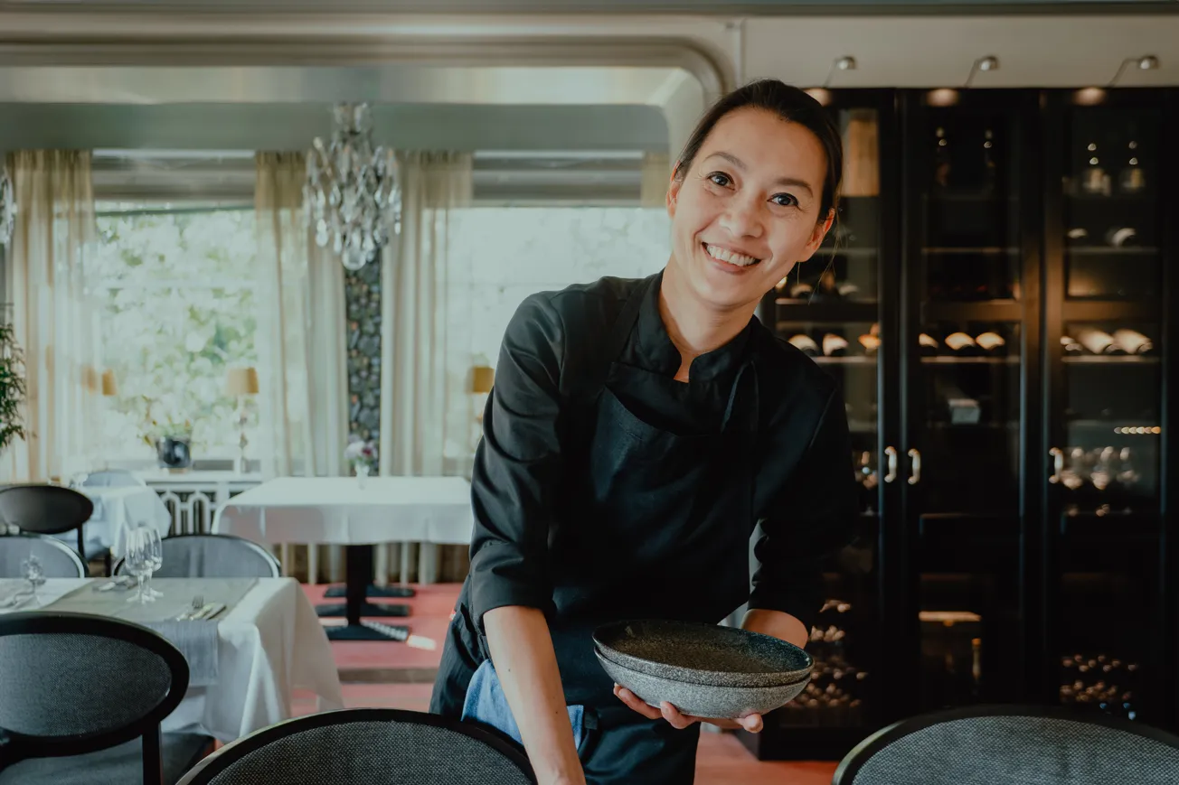 Tjej ler mot kameran medan hon dukar inför servering på restaurang