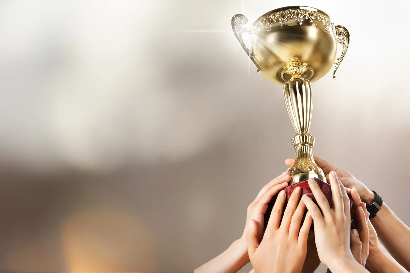 En grupp människor som håller upp en pokal.