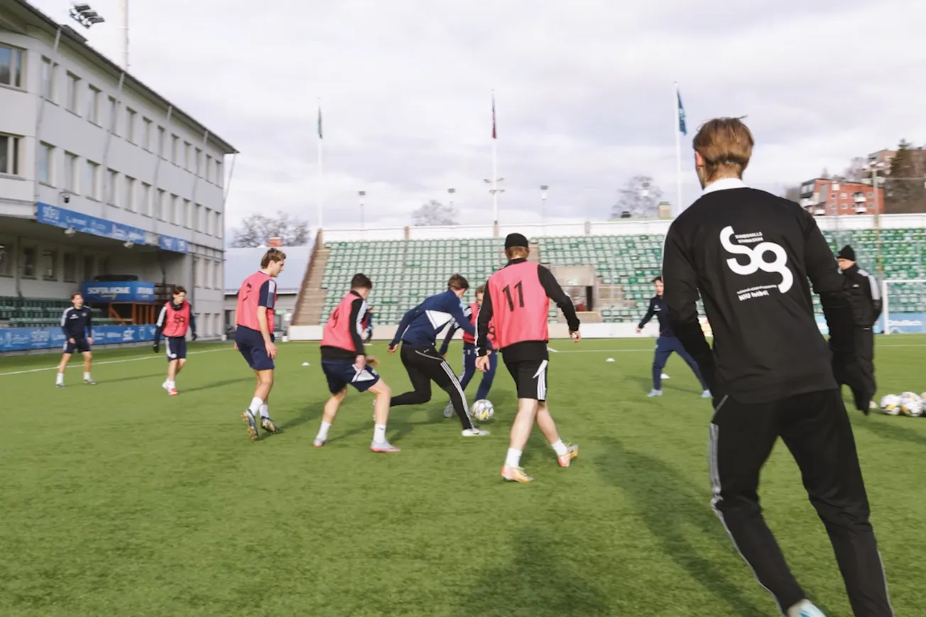 En grupp unga män som spelar fotboll.