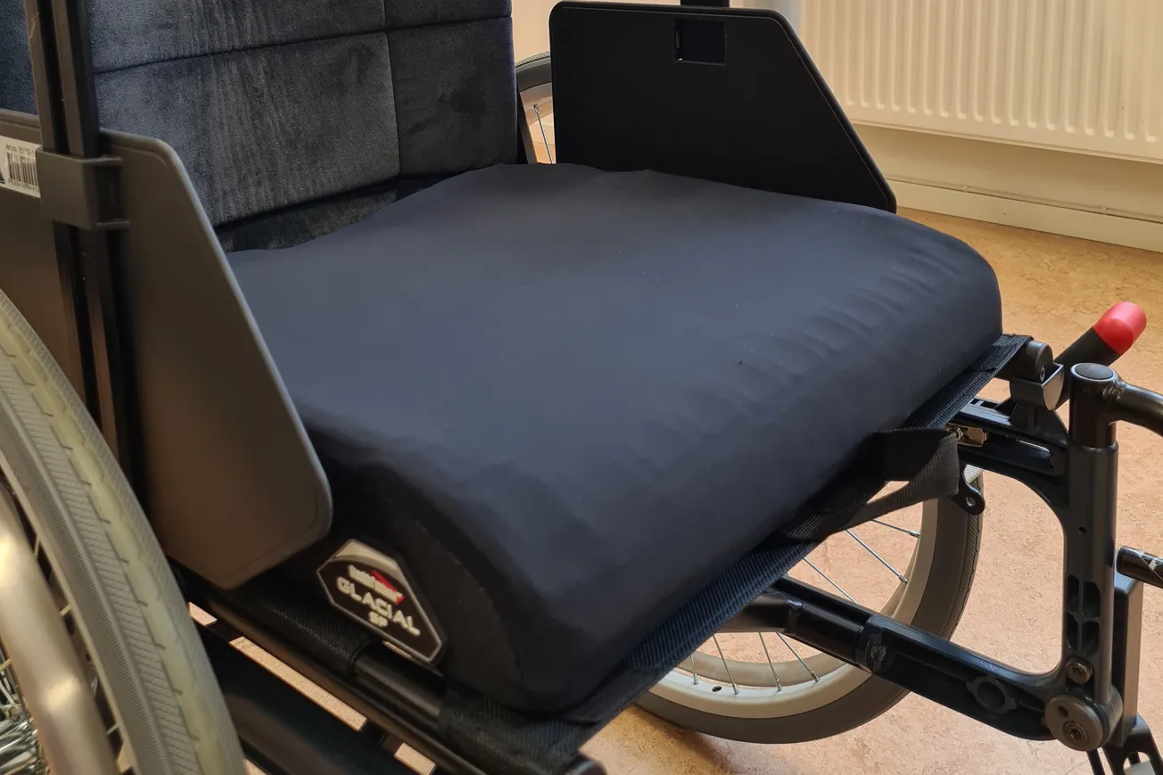 En sittdyna med överdrag placerad i en rullstol.