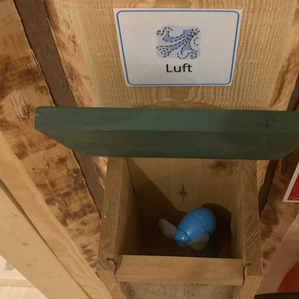 En trälåda med ett blått föremål inuti.