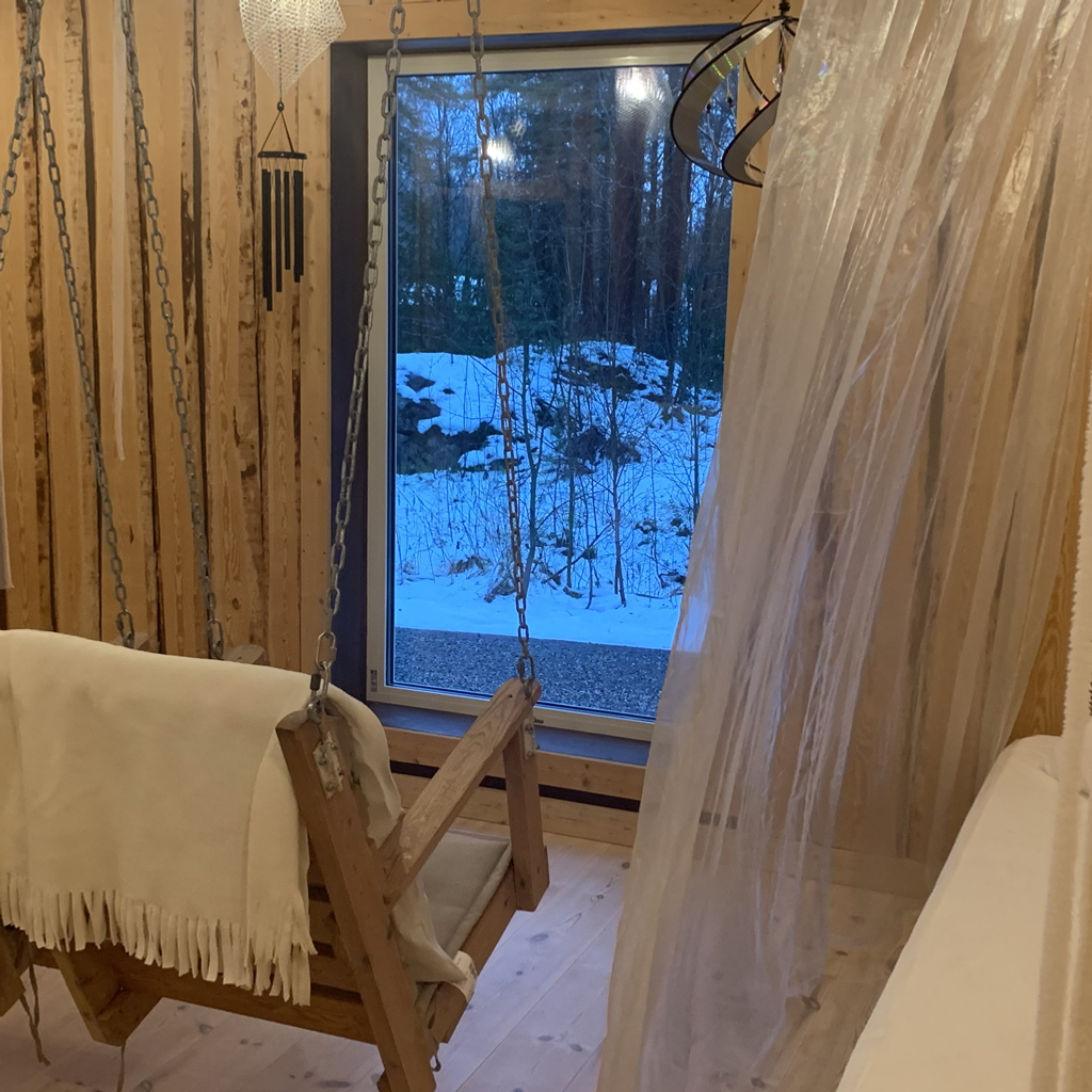 Ett sovrum med en gungbädd och ett fönster.