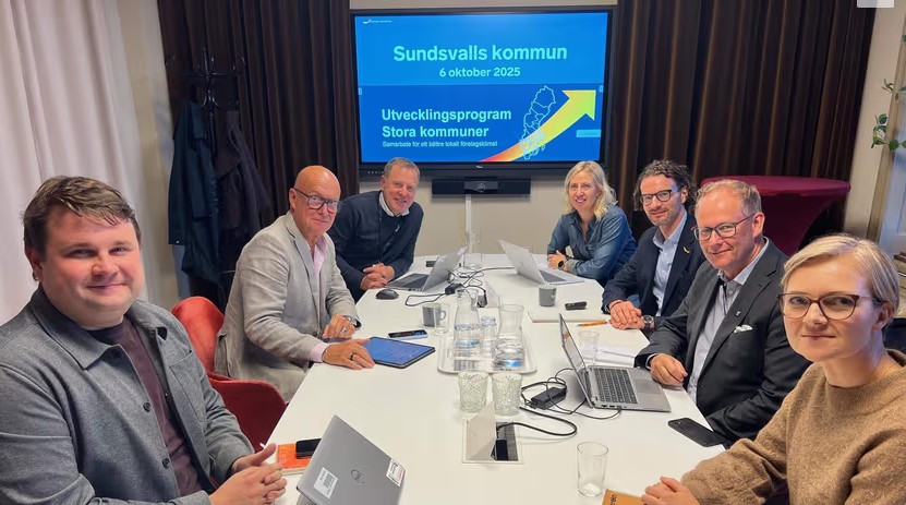 Ett gäng sitter samlat runt ett konferensbord.