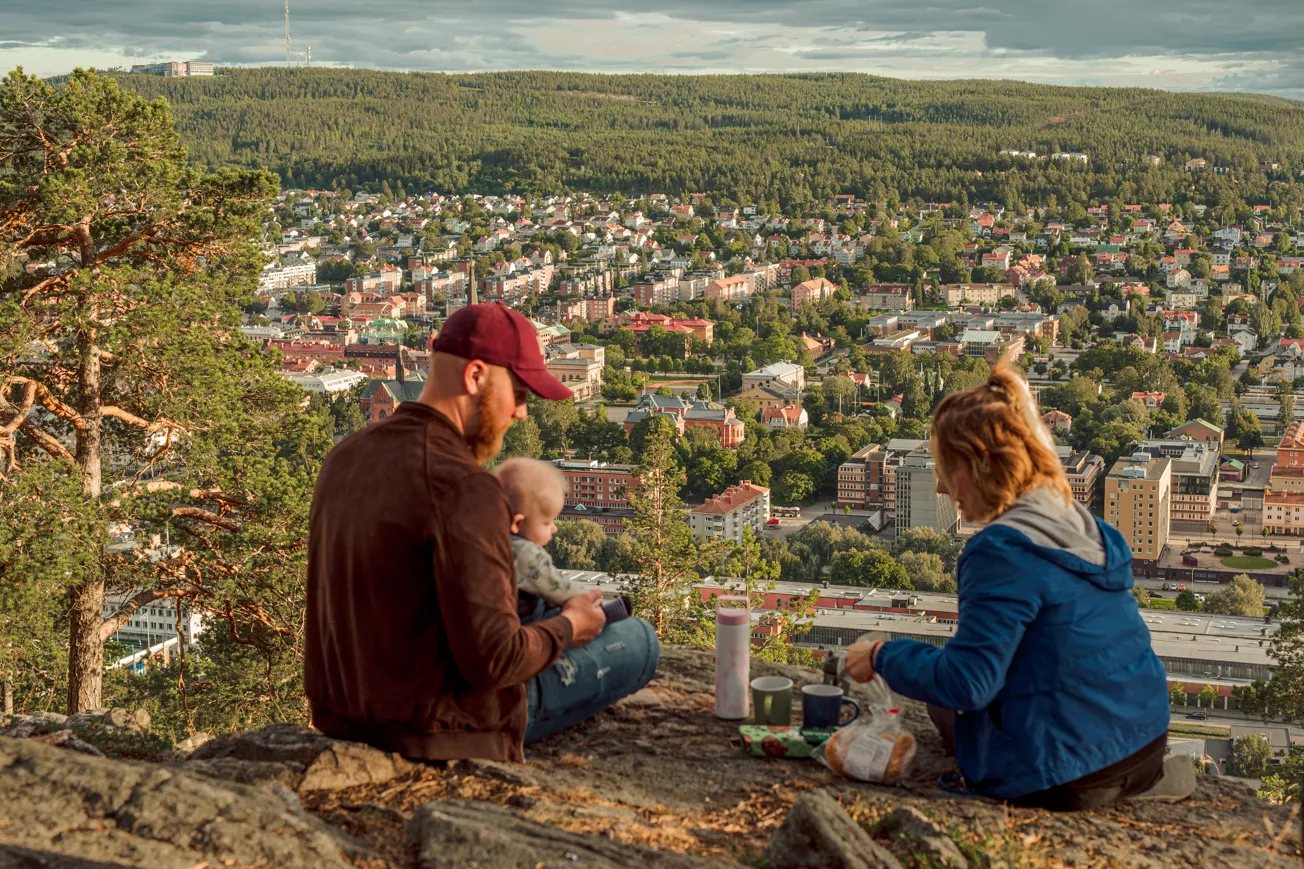 En man och en kvinna sitter på toppen av en kulle.
