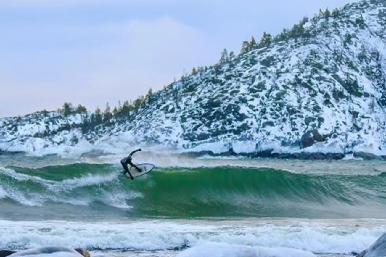 En man rider på en våg på en surfbräda.