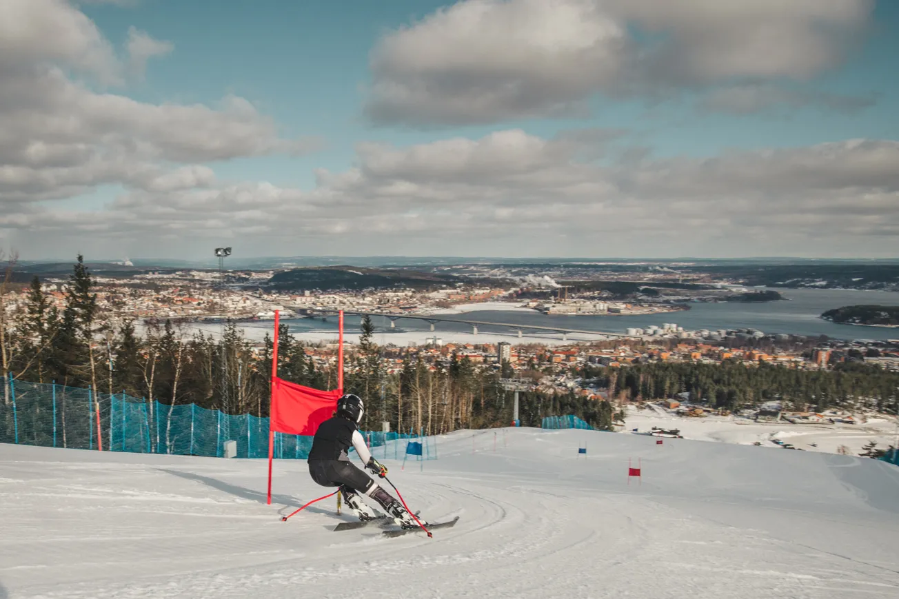 En person på skidor som åker nerför en snöig backe.
