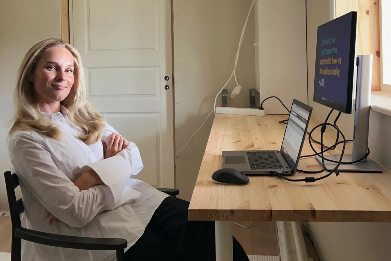 En kvinna sitter i en stol framför en dator.