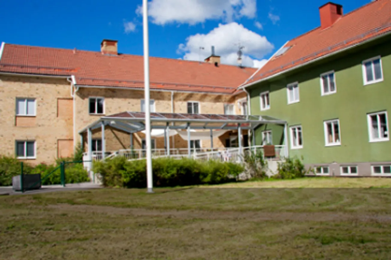 En grön byggnad med en flagga framför sig.