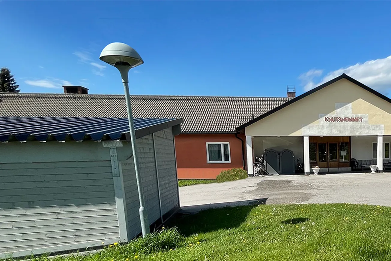 En byggnad med en parkeringsplats framför sig.