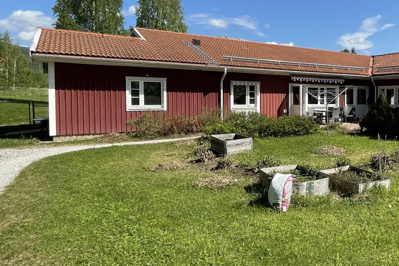 Ett rött hus med rött tak och vita fönster.