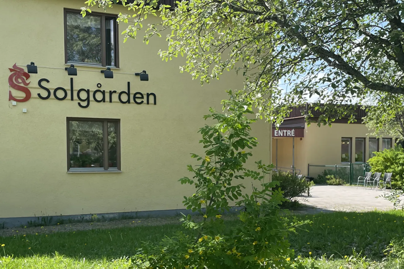 En gul byggnad med en skylt på sidan av den.