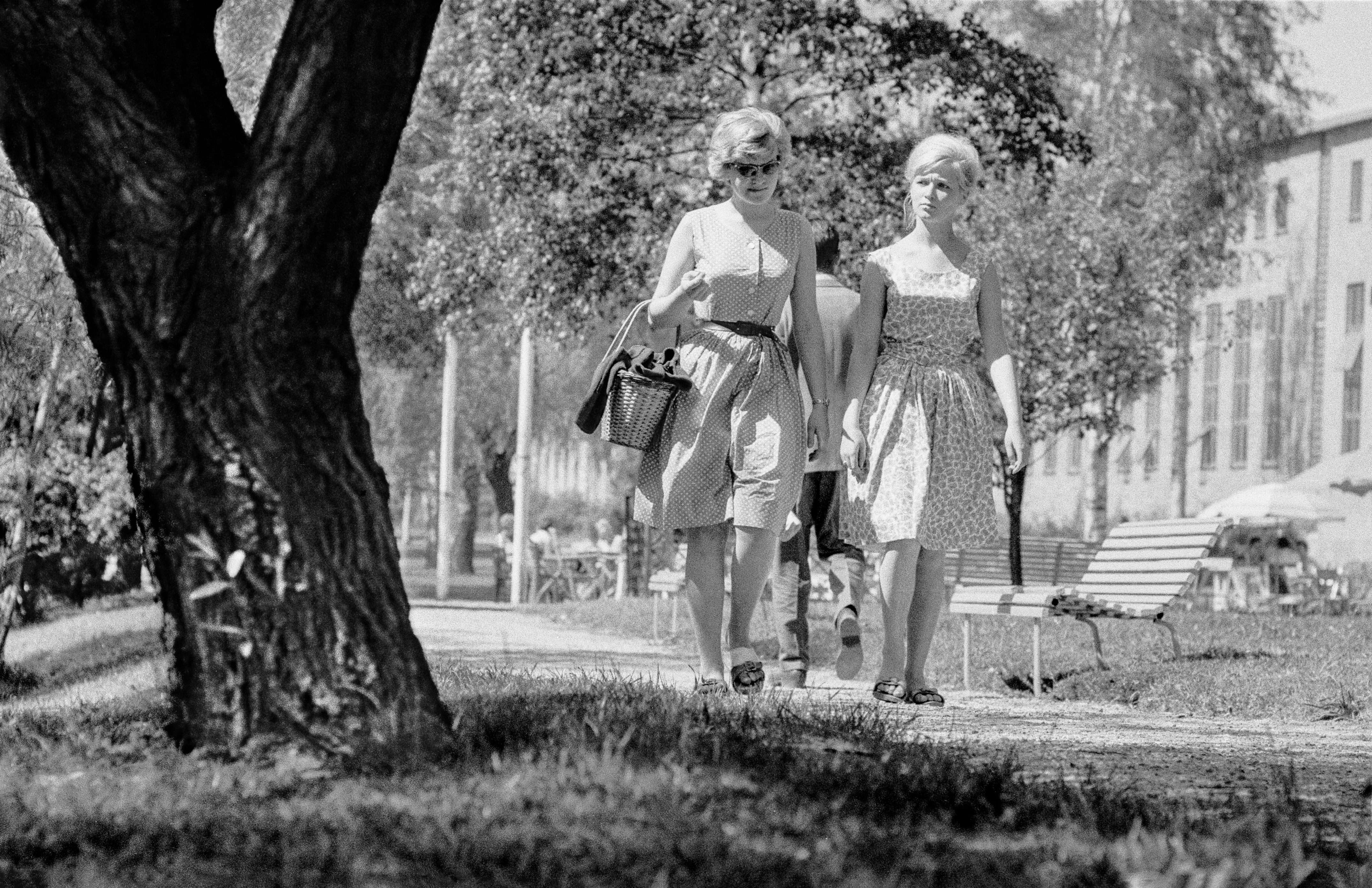 Tre personer promenerar i solen längs Selångersån.