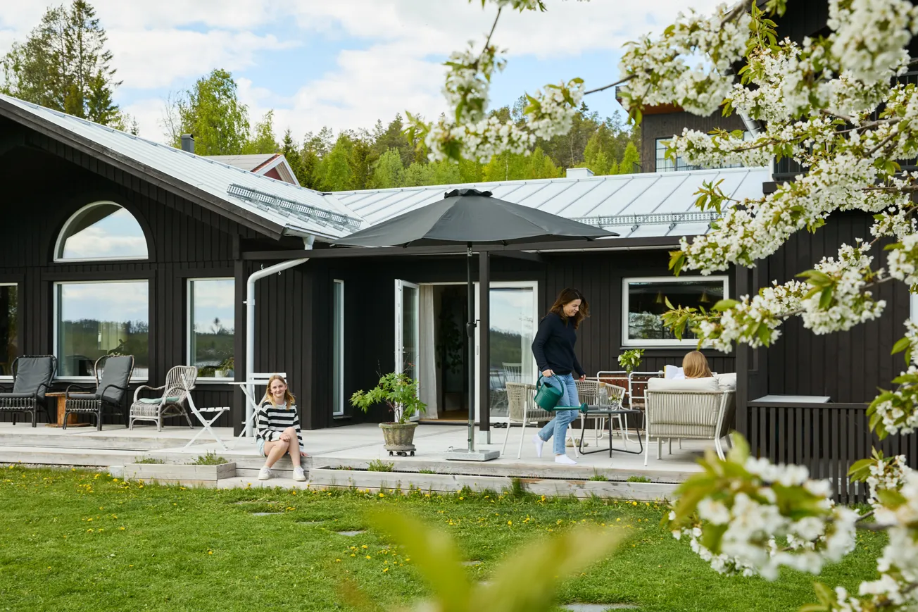 En kvinna och ett barn som går mot ett hus.