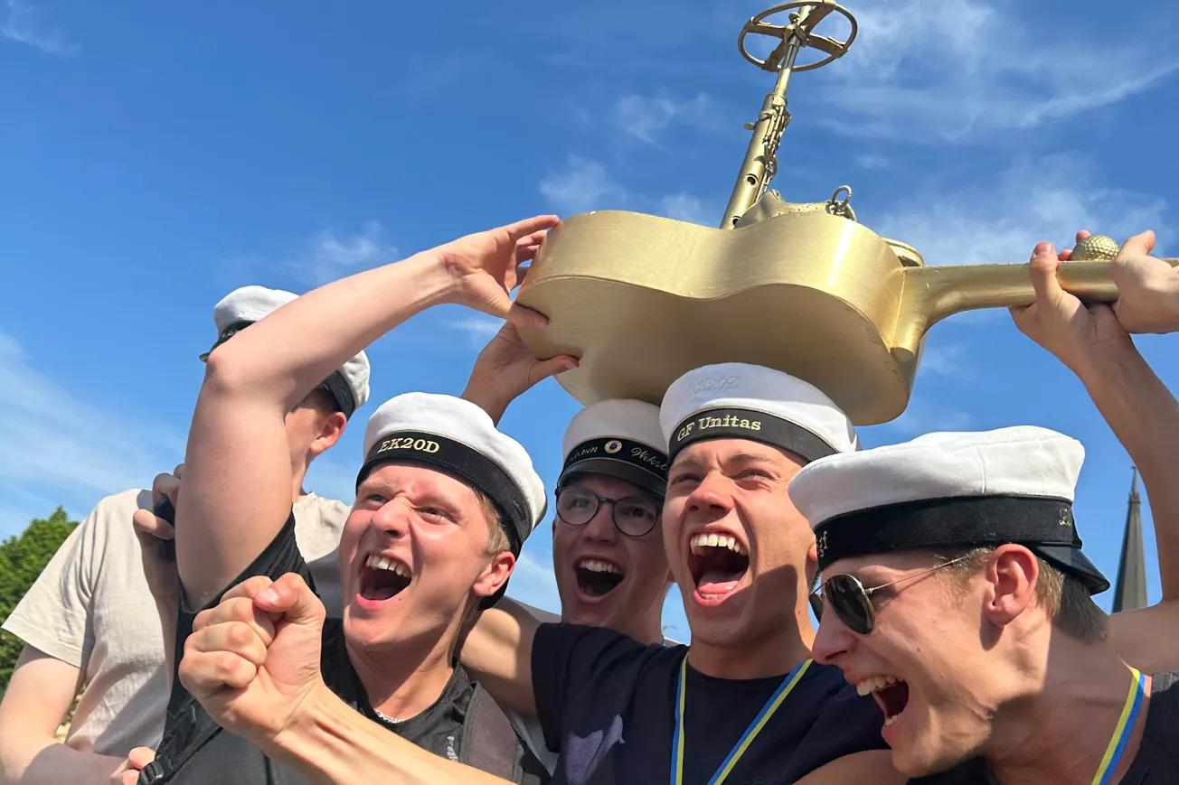 En grupp män som håller upp en trofé.