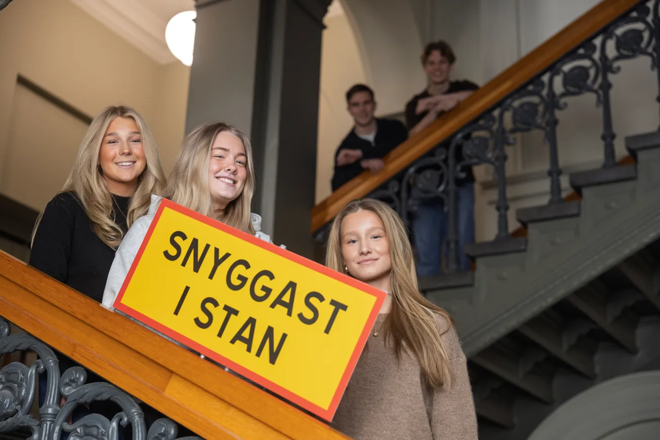 En grupp människor som håller en skylt där det står snyggast i stan.