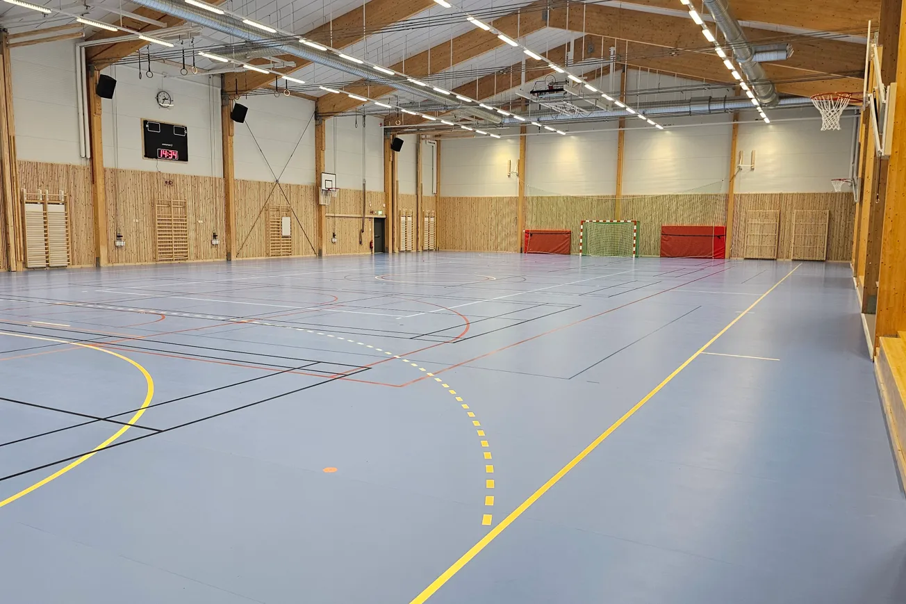 Idrottshall med många linjer på golvet för olika idrotter.