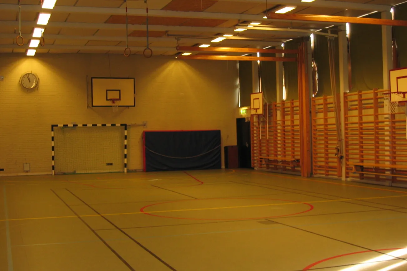 Idrottshall med linjer på golvet för olika idrotter.l