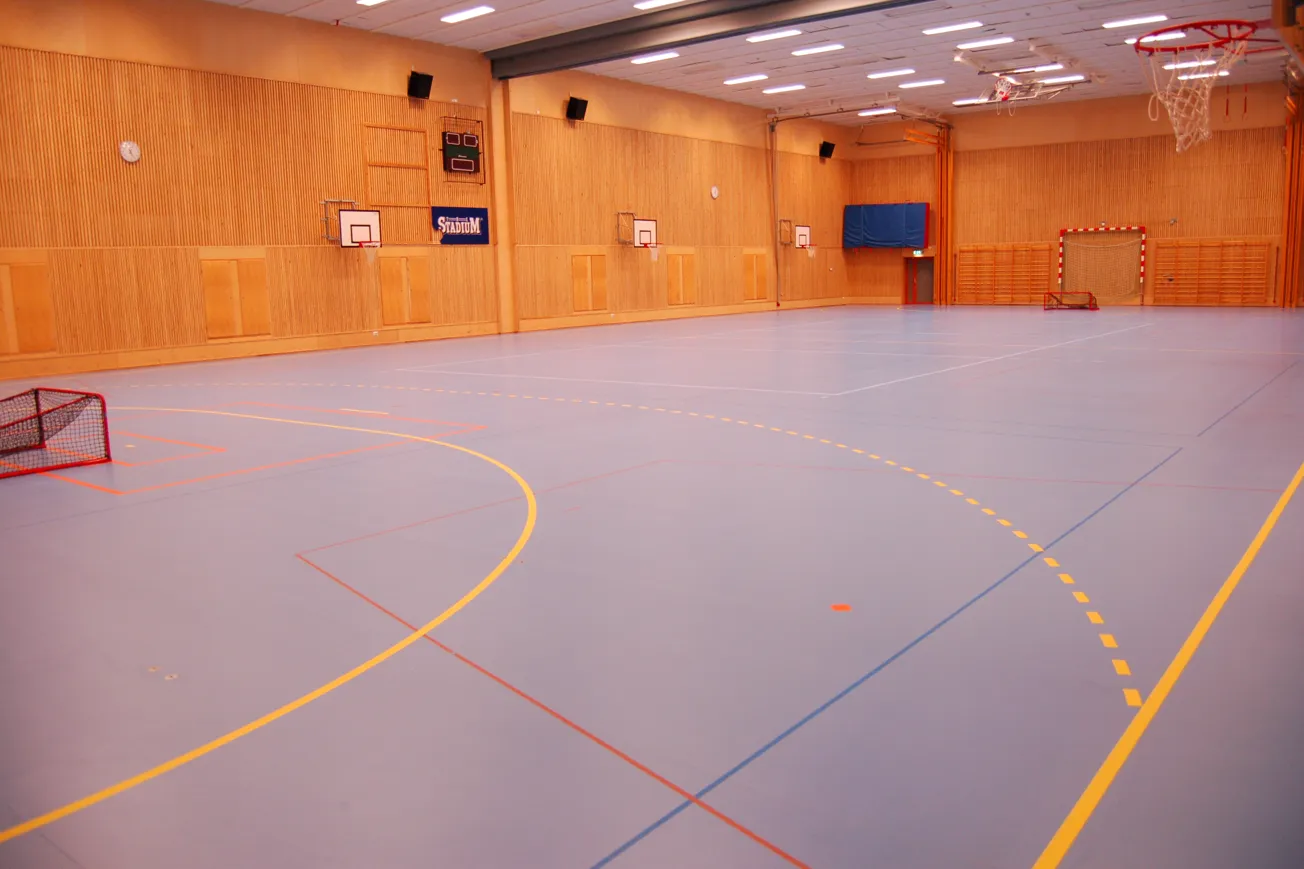 Idrottshall med linjer på golvet för olika idrotter.