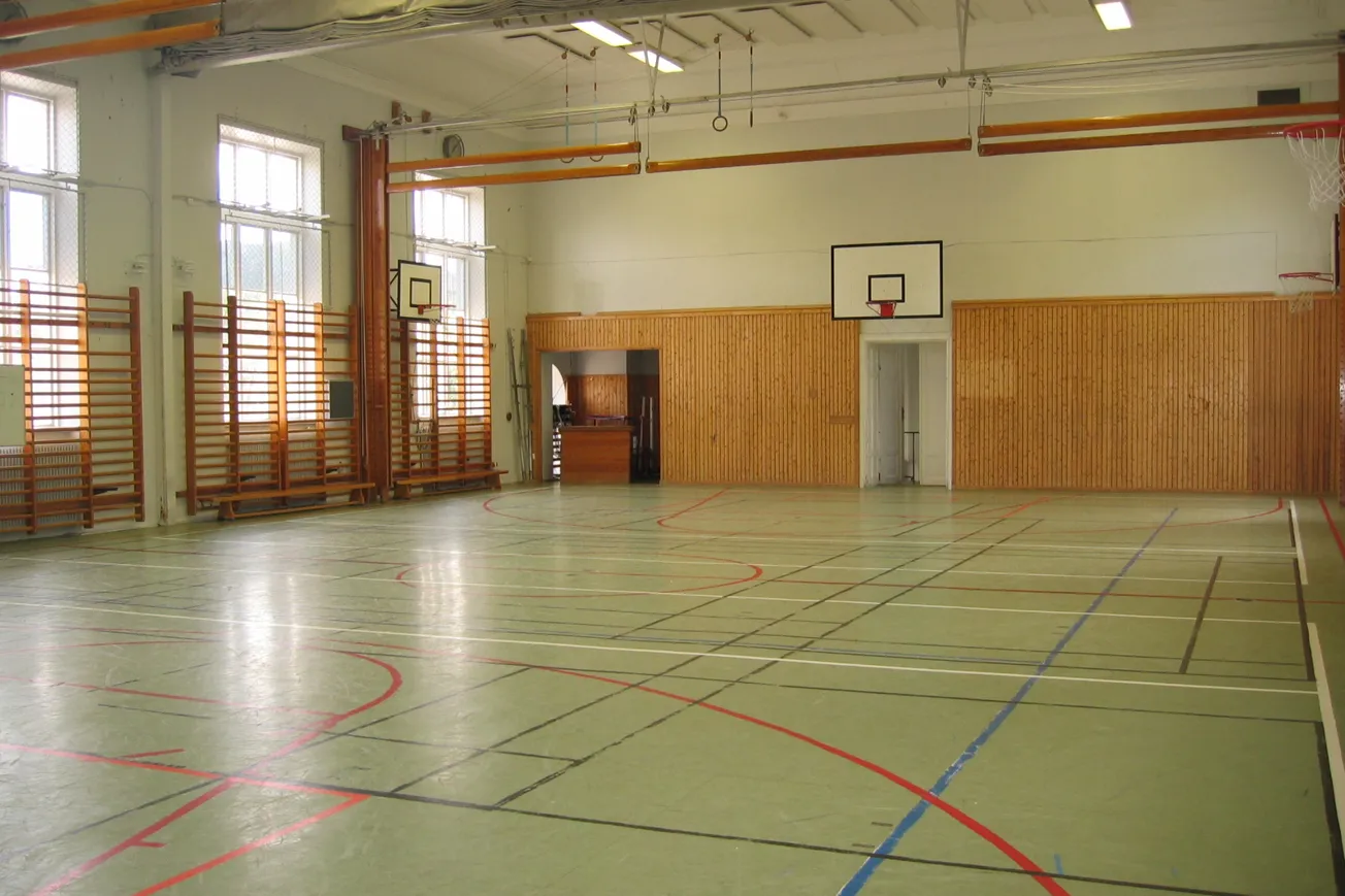 Idrottshall med linjer på golvet för olika idrotter.