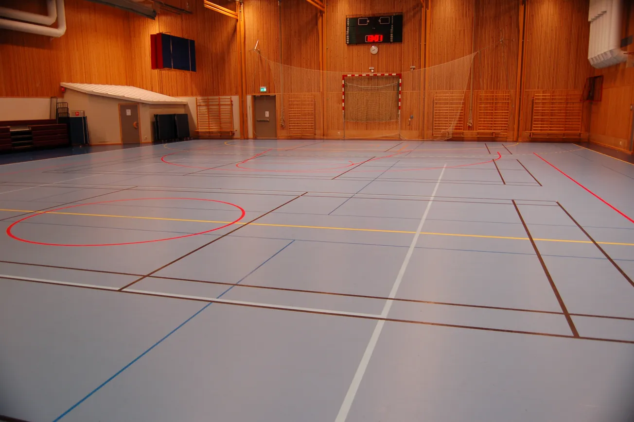Idrottshall med linjer på golvet för olika idrotter.