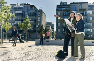 Två kvinnor som står bredvid varandra med karta och papper i händerna. Foto: Kristofer Lönnå