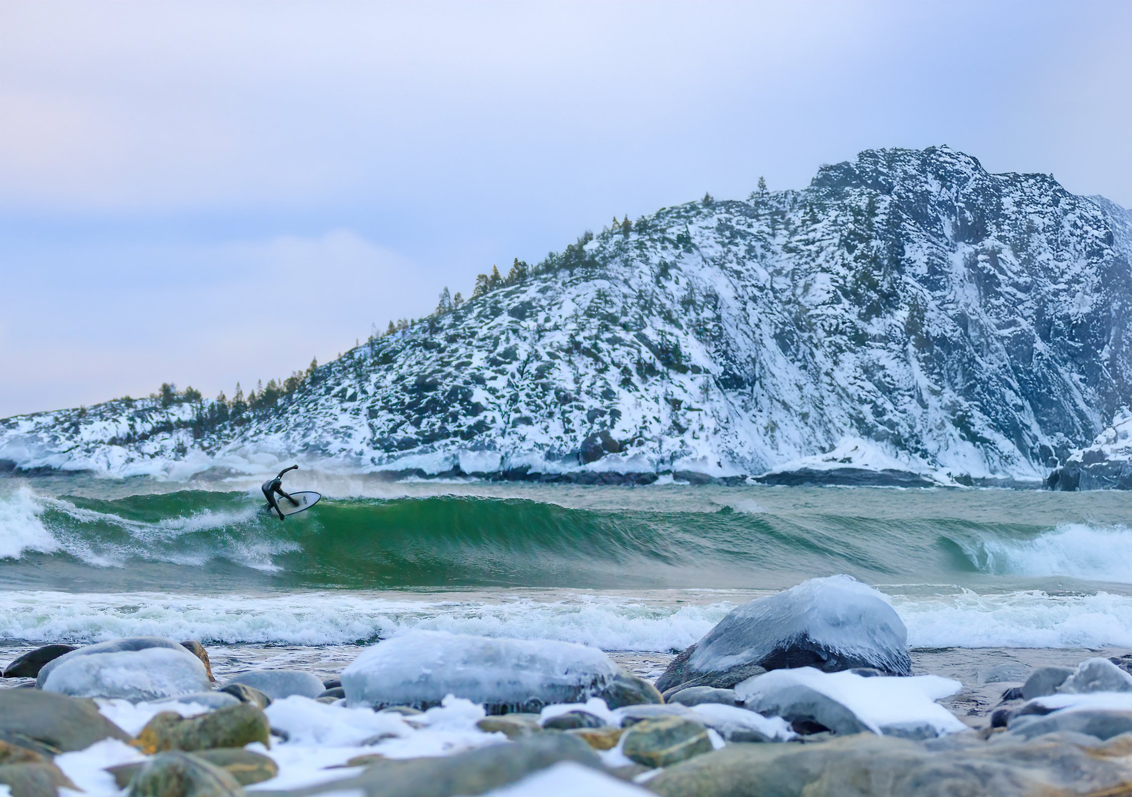 A surfer surfing a wave during winter.