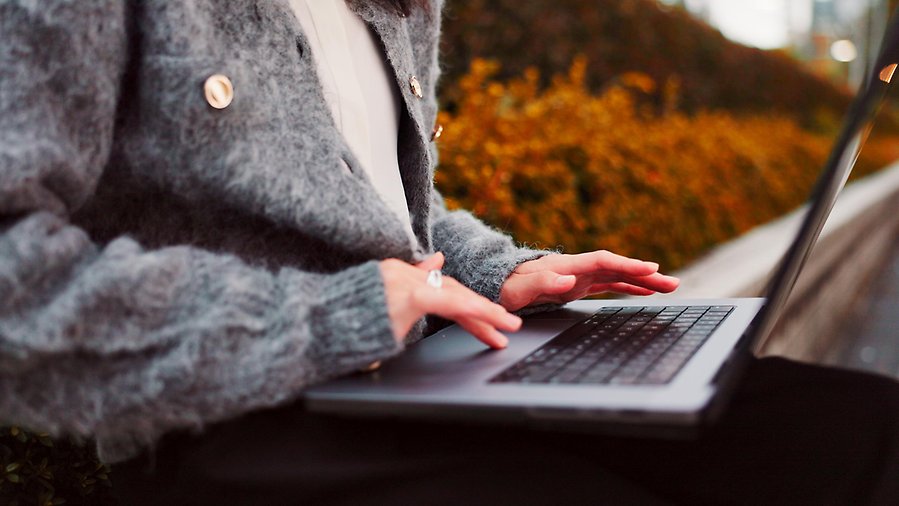 Person som skriver på laptopdator som ligger i knä