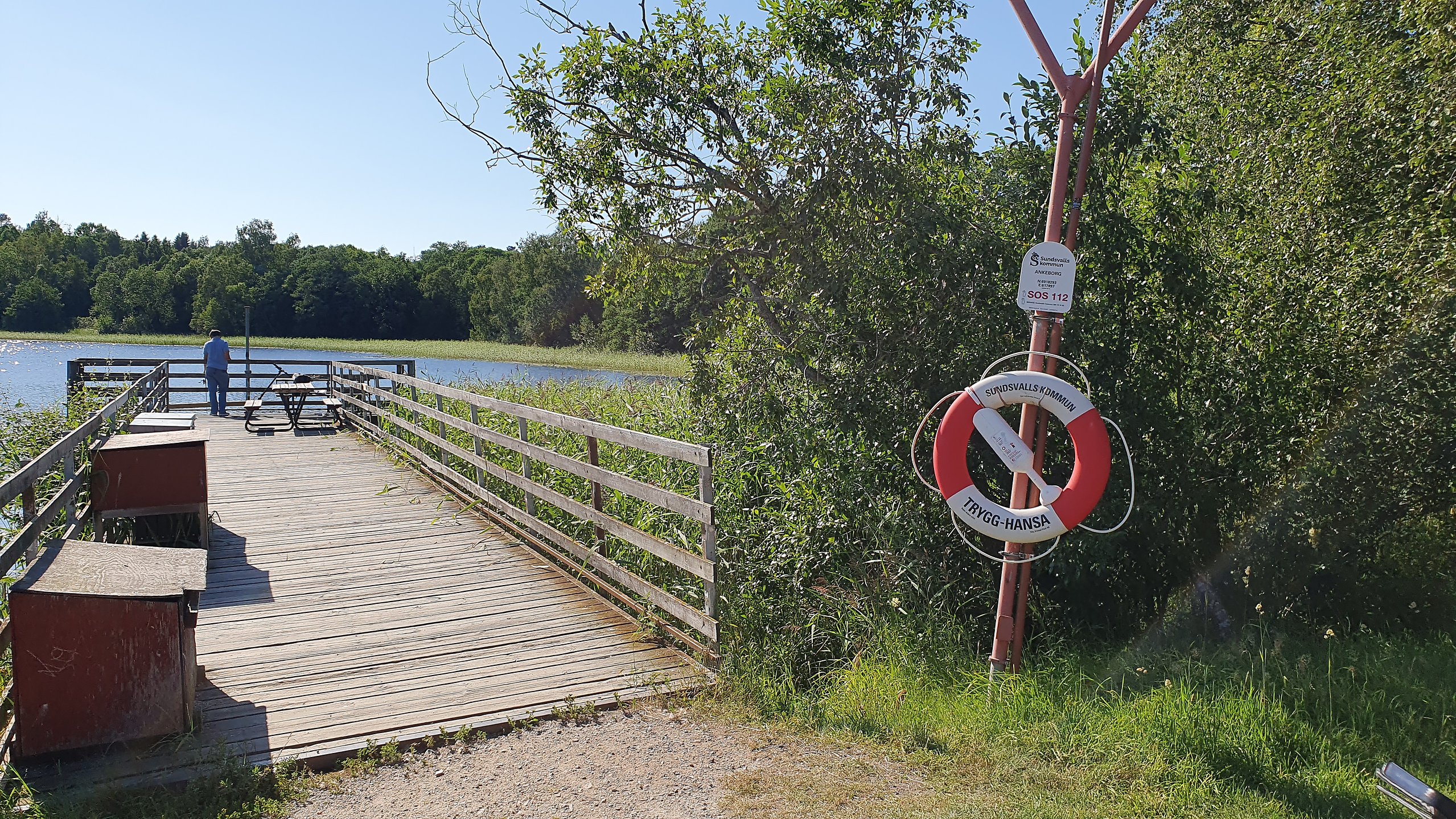 En brygga ut i en sjö och en livboj vid bryggan.