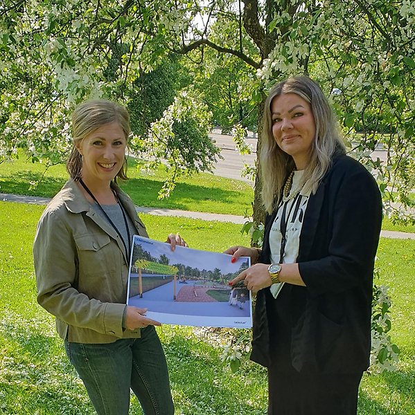 Malin Edström, landskapsarkitekt och Jeanette Hedlund (S), stadsbyggnadsnämndens ordförande visar en bild av Dinosaurielekplatsen.
