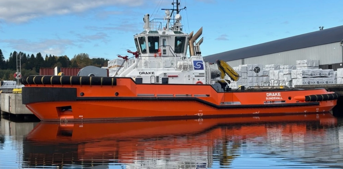 En stor röd bogserbåt som heter m/s Drake. 