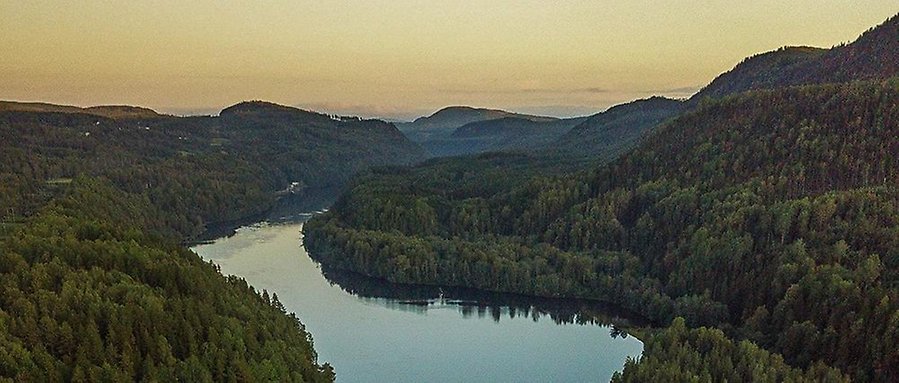 Foto: Vybild över Indalssälven i Liden. Älven ringlar sig fram mellan gröna dalar.