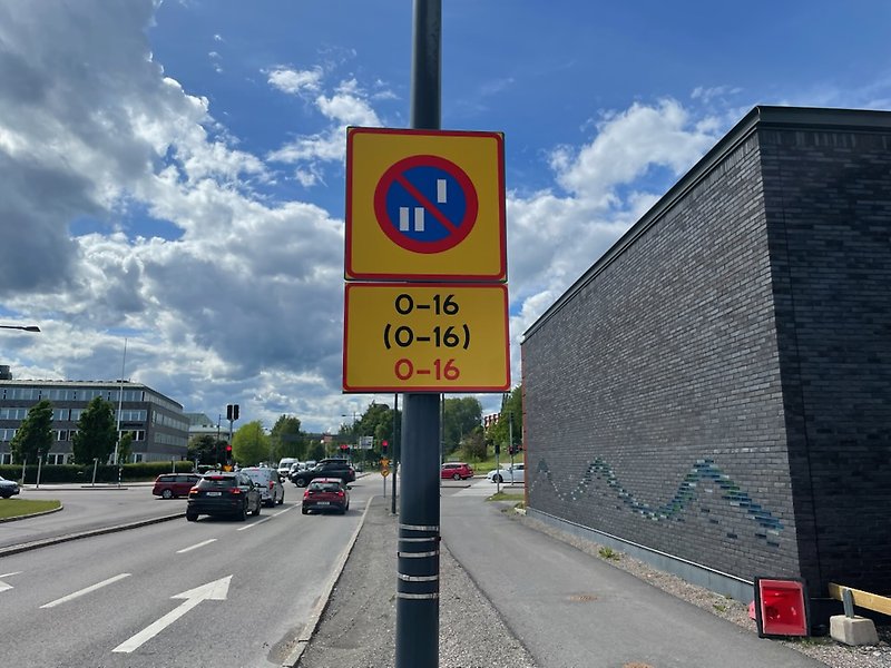 Trafikskylt står längs en väg och visar datumparkering.